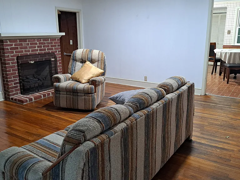 Living room with kitchen entrance at back. Bedrooms entrances are from left and right side of living room.