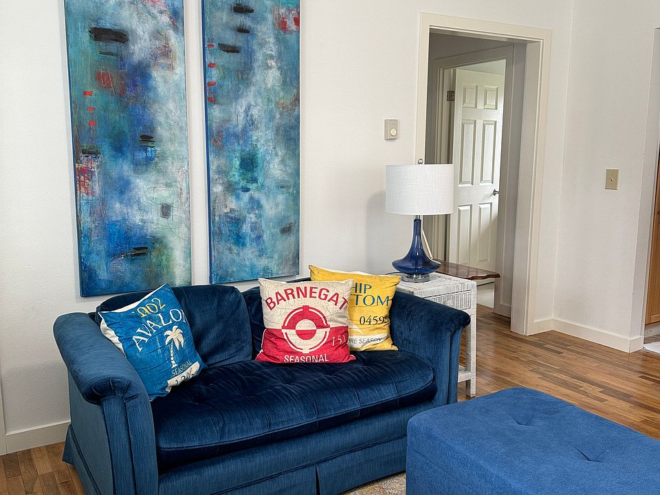 Living room with fireplace, dining area, and room for large TV on opposite wall. 

Fine Art throughout the cottage. Other art choices are available based on tenant preferences.