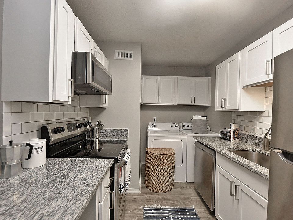 Kitchen with granite counters, washer & dryer, modern cabinetry, and stainless appliances