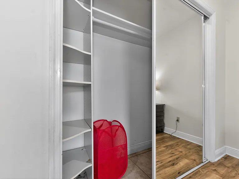 Built-in closet with adjustable shelving and hanging rod offers convenient storage for clothing, linens, and essentials.