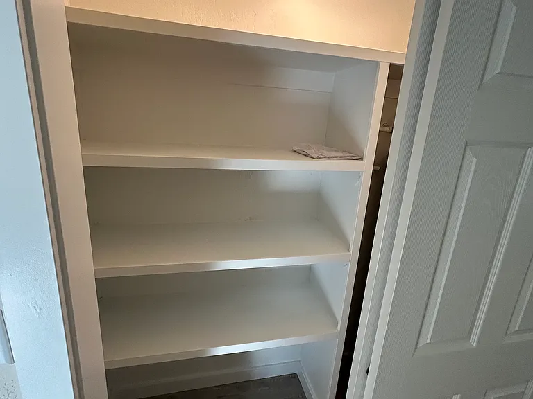 Hallway closet, shelves on the left, water heater stored on the right.