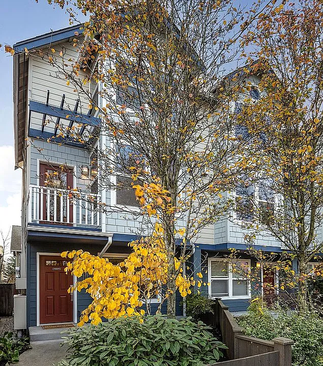 Street view from 15th Ave. East facing townhome with fully fenced front yard and professionally landscaped garden entry. Landscaping maintained by landlord.