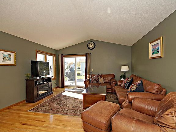 Large living room with gleaming hardwood floors, soaring vaulted ceilings and tons of natural light!