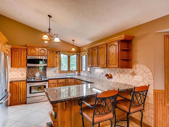 Updated kitchen with vaulted ceilings, tile flooring, new stainless steel appliances and Granite countertops as well as ample counter-space and cabinetry!
