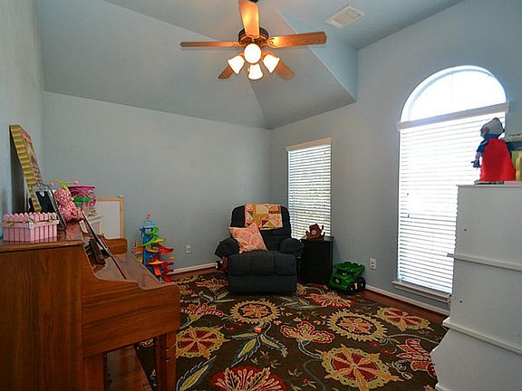 French doors open to the study accented by hardwood floors, raised ceilings and a ceiling fan with light fixture.