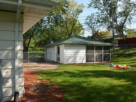 Backyard view showing the patio area, play area, and the screened-porch attached to the garage.