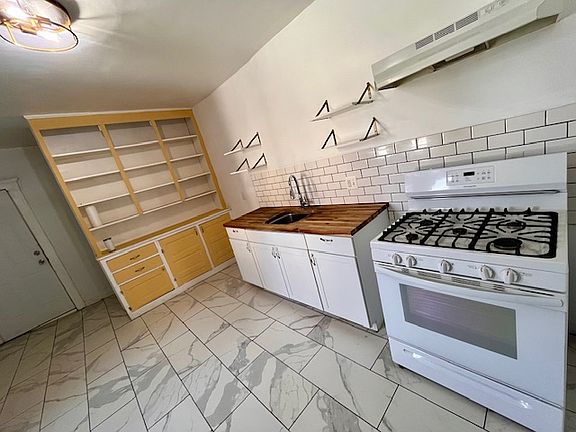Butcher block counter, gas range, new fridge, new fixtures, porcelain tile
