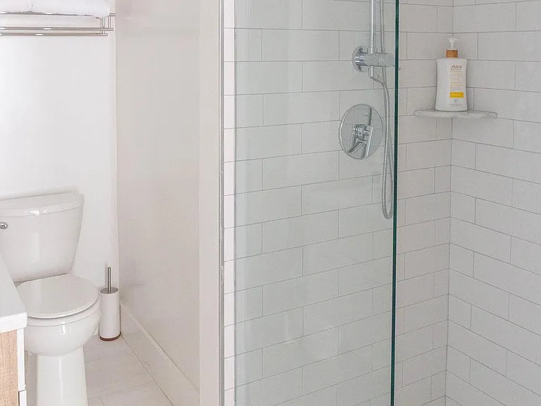 Second full bathroom w rain head, hand held shower, soft close toilets, vanity and mirror with storage.