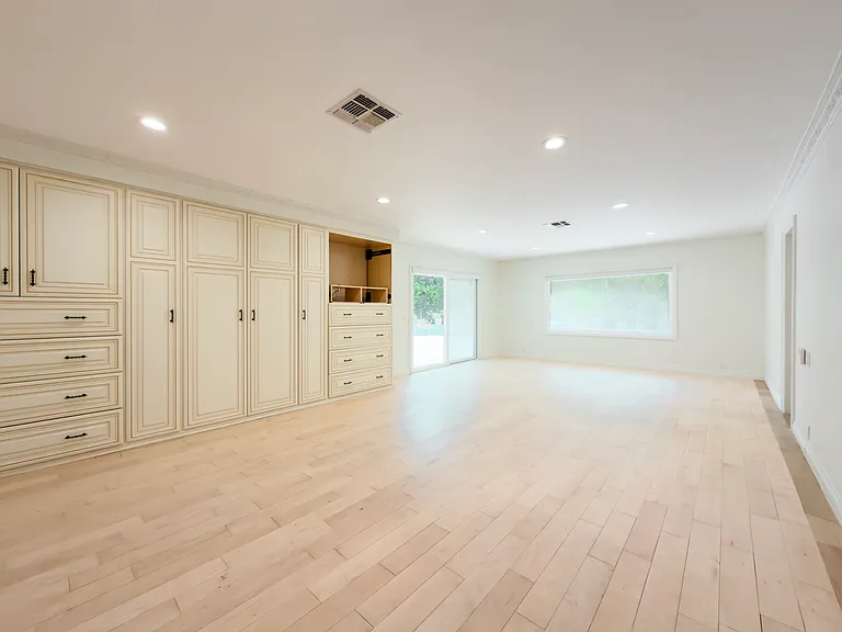 Extensive built-in wardrobes and patio access define this unfurnished primary bedroom in a Beverly Hills luxury rental at 1094 Garden Lane, 90210.