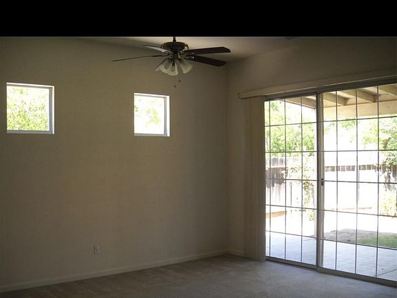 Open concept living room and dining area. New carpeting and epoxy aggregate flooring throughout. Indoor laundry room with plenty of storage. Sliding glass door leads to a spacious covered patio and large newer fenced backyard.