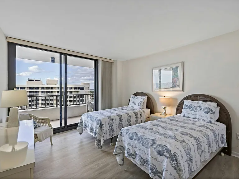 Second bedroom featuring twin beds and a dresser for storage