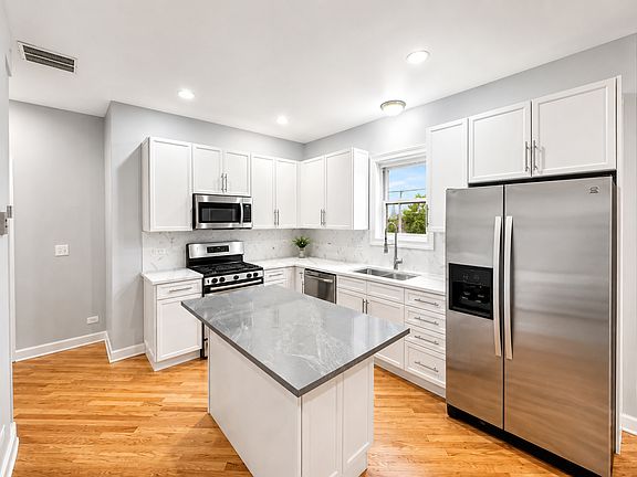 Spacious white kitchen with quartz countertops