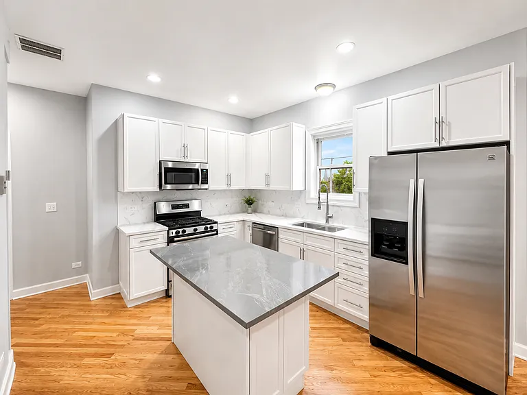 Spacious white kitchen with quartz countertops