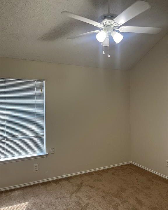 Unfurnished room with carpet floors, ceiling fan, and a textured ceiling
