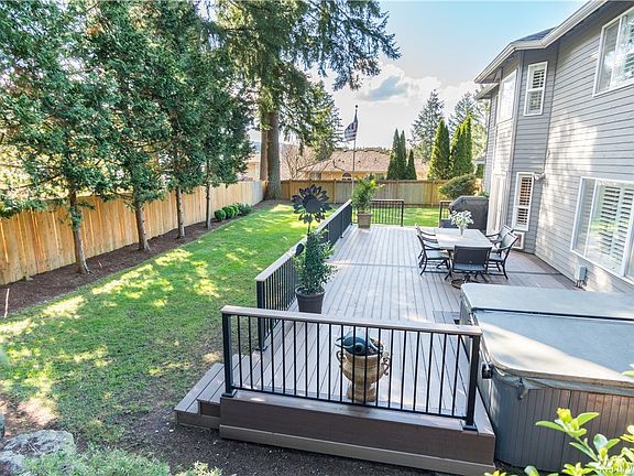 An expansive back deck with sunken hot tub (included) / Extra storage shed out back too.
