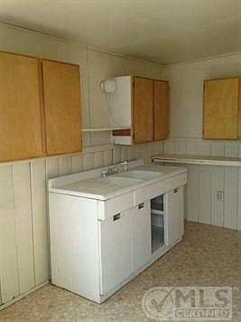 Kitchen with metal lower cabinets, wood upper cabinets and linoleum floor