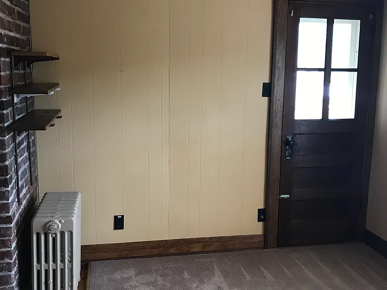 Sunroom with brick wall, shelves, doorway to small balcony
