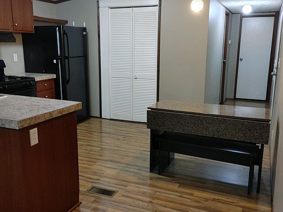 Kitchen area with pantry behind white door on left. Back hall is master bedroom and bathroom on left