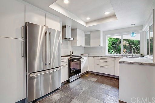 Beautifully upgraded kitchen with leathered quartz counters, white cabinets and stainless appliances