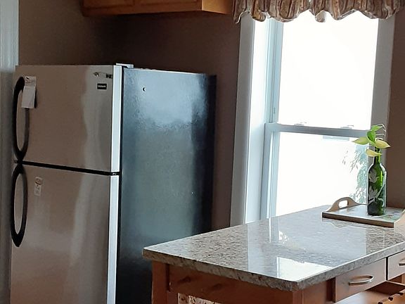 Large Kitchen with rolling carts. (1 granite, 1 stainless steel) Black and stainless steel appliances.