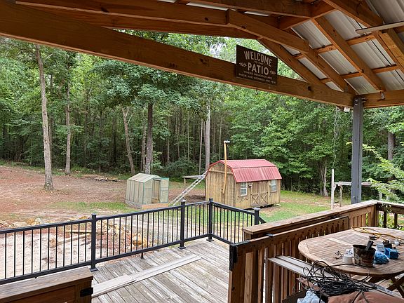 Covered deck with extended deck and stairs to the side Green house and wired utility barn