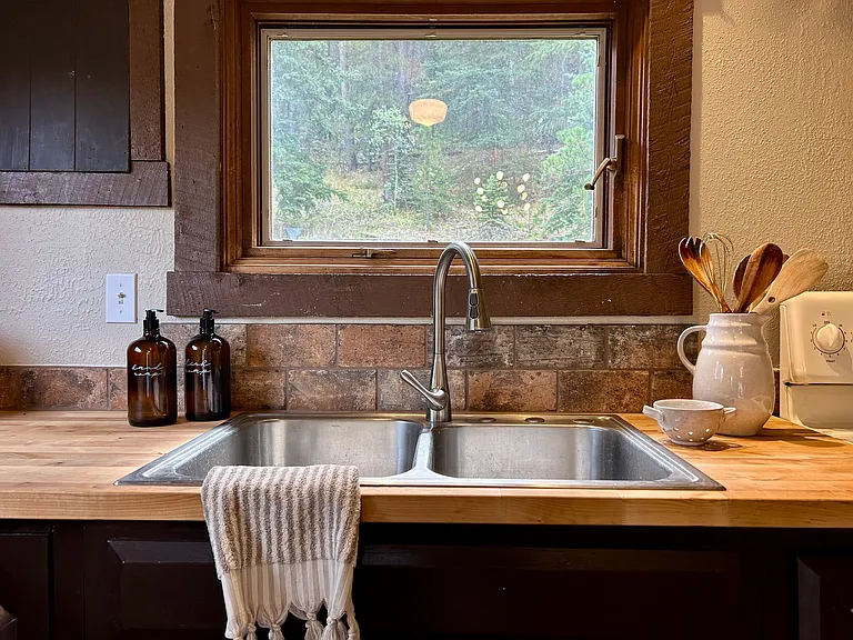 Forested views off the sink and stone backsplash around the entire kitchen
