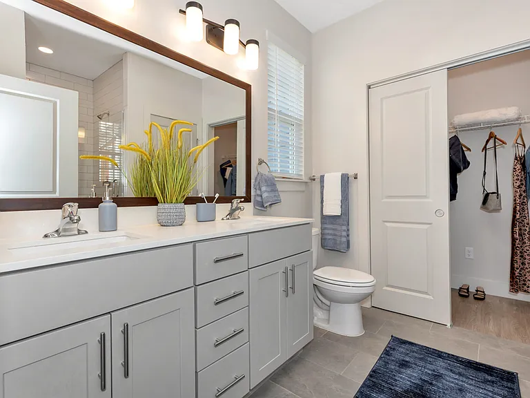 Bathroom with Dual Sinks, Framed Mirror, and Closet