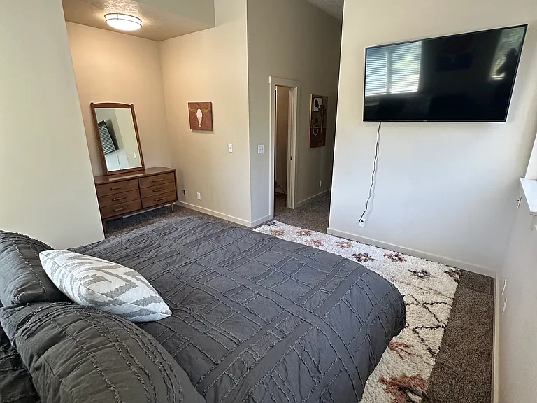 Primary bed (king bed) with 40" TV hung on the wall
