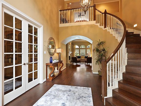 The updated hardwood floors invite you into this custom home with a sweeping, lighted staircase and views all the way through to the backyard. The same hardwood flooring continues on the staircase and the upstairs hallway.