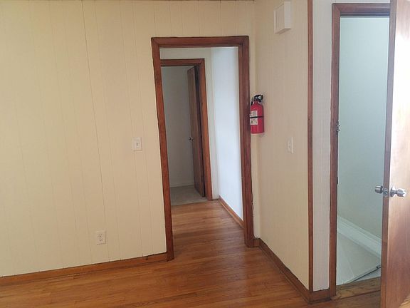 Living room, showing entry door and hallway to kitchen and bathroom