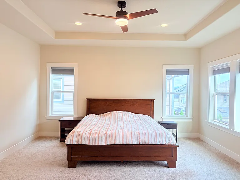 Master bedroom with ceiling fan. Top_down bottom_up cellular shades: daylight above, blackout below