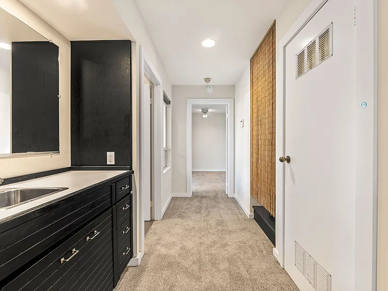 Hallway with Wet Bar on Left and Washer/Dryer Closet on Right