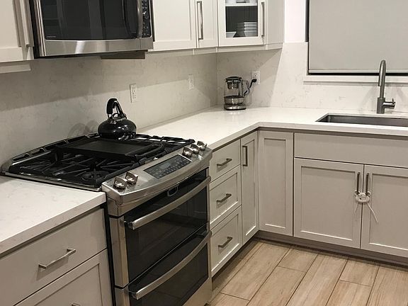 New kitchen with quartz counters, custom cabinets, stainless steel appliances