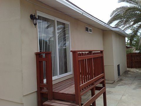 Back of the house w/ wooden deck from master bedroom leading to private patio