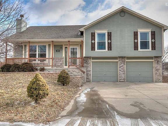 Awesome curb appeal featuring covered front porch, stone landscape walls, and brick trim.