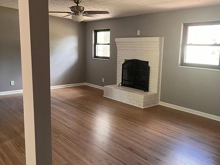 Living room with fireplace. Newly refinished oak floors throughout. all new blinds throughout. all new ceiling fans throughout.
