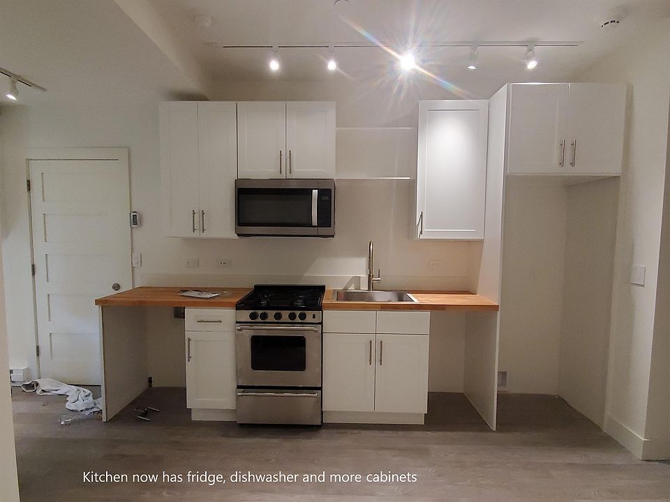 Kitchen now has fridge, dishwasher, and more cabinets.