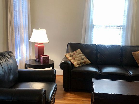 Spacious living room. Leather sofa and chair set and tables furnished, as needed.