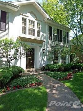 A gracefully curved walkway leads to the front door.
