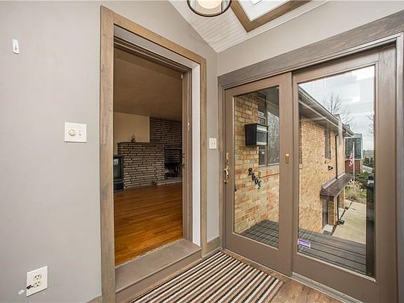 Entry to home is newer sun room with vaulted ceiling.