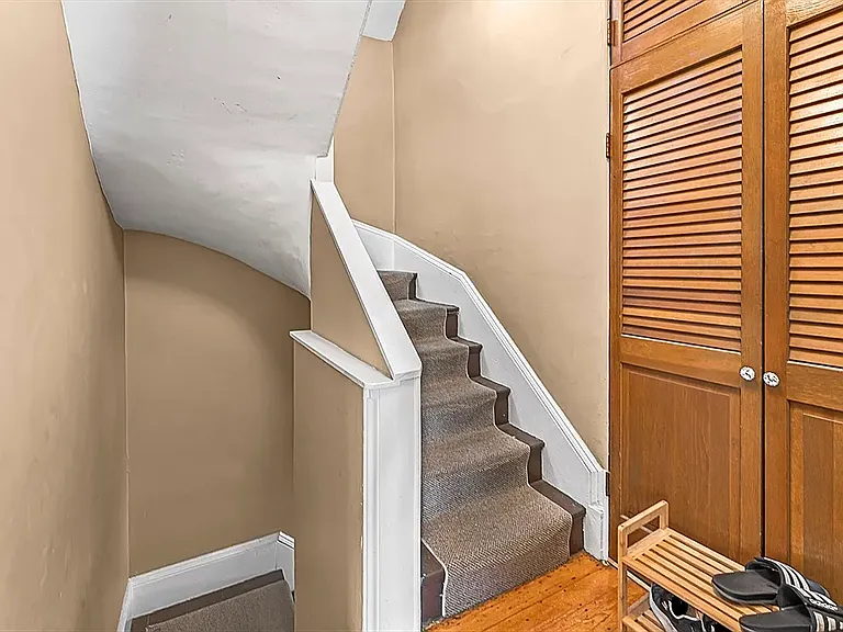 Staircase between floors and entryway closet