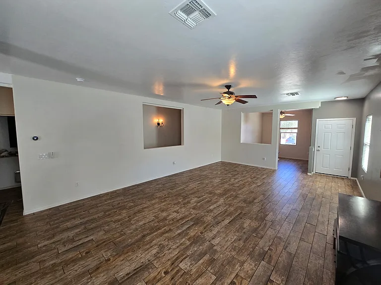 Living room with view of den/office and front door.