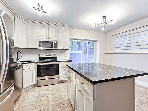 Brand-new kitchen with new stainless steel appliances, large island and quartz counter tops. Dining area features a sliding door to the private patio.