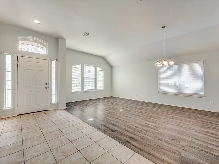 Foyer entrance featuring a white paneled door with sidelights and an arched transom window