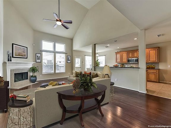 Great room has vaulted ceilings and surrounds a fireplace.