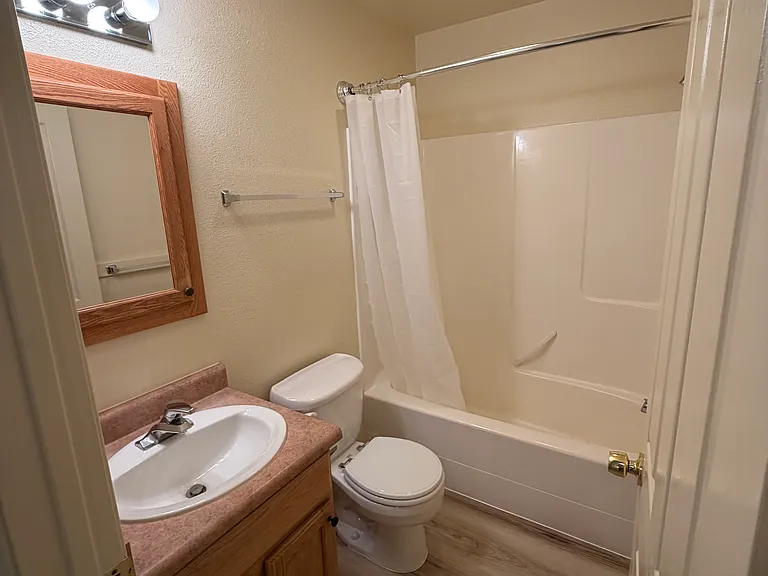 Main bathroom with curved shower curtain rod for more elbow room.