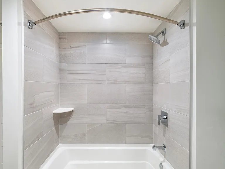 Sleek tile surrounds and polished fixtures bring a refined touch to bathrooms at Modera Aventura.