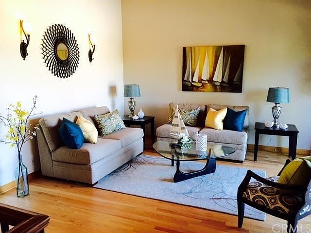 Light and airy living room with vaulted open beamed ceilings, deck and fireplace.