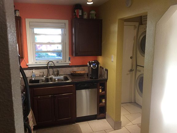 Kitchen through to back door. Range and Fridge on left of L w/ upper cabinets.