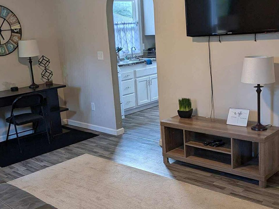 Spacious living room with sofa and chair, smart tv.